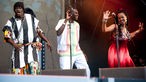 Der Sänger wird von einer Sängerin im roten Kleid begleitet. Links von Youssou N'Dour steht ebenso ein anderer Sänger im schwarz-weiss gestreiftem Hemd