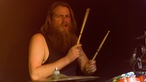Drummer spielt am Schlagzeug mit offenem Mund
