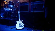 Die Gitarre von Josh McClorey steht vor zwei VOX-Verstärkern auf der dunklen Bühne.