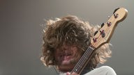 Der Frontman beim Gitarre spielen aus Froschperspektive - am meisten zu sehen: Haare!