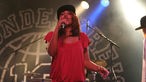 Joy Denalane für den Freundeskreis am Mikrofon beim Underground Festival 2007, sie trägt ein rotes Oberteil und eine schwarze Kappe.