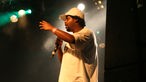 Afrob steht mit weißem T-Shirt und weißer Kappe mit seinen Kollegen vom Freundeskreis auf der Bühne und performt beim Underground Festival 2007
