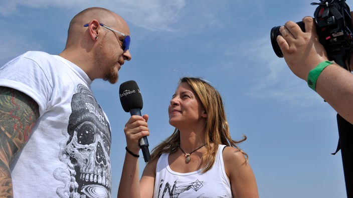 Veranstalter Sven Borges wird interviewt von Rockpalast-Reporterin Conny Schiffbauer