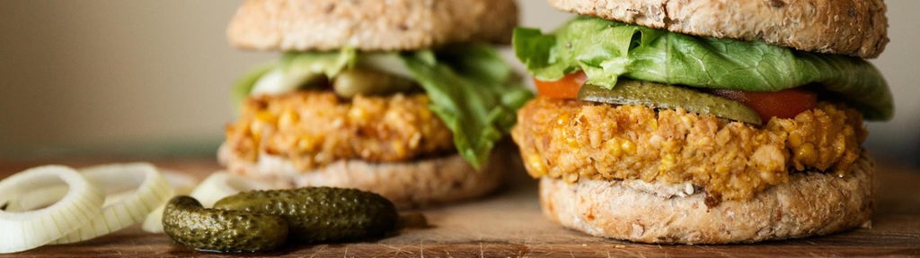 Das Bild zeigt einen veganen Burger mit einem Maispattie.