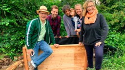 Auf dem Bild sieht man Yvonne Willicks (r), WDR-Moderator Daniel Assmann (2.v.l), WDR- Gartenexperten Markus Phlippen (l) mit Familie Westendorff sowie ein Hochbeet.