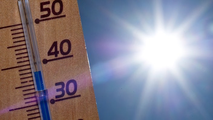 Ein Thermometer zeigt 38 Grad, im Hintergrund die Sonne