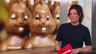 Die Moderatorin im SZ Studio vor einem Bild von Schokoladen-Hasen