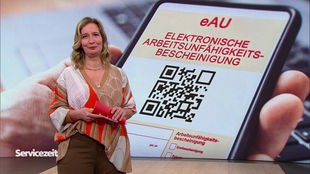 Die Moderatorin im SZ-Studio vor dem Bild eines Mobiltelefons mit einer digitalen Arbeitsunfähigkeitsbescheinigung