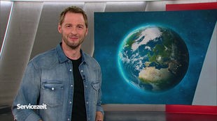 Der Moderator Dieter Könnes im SZ Studio vor einem Bild der Erde