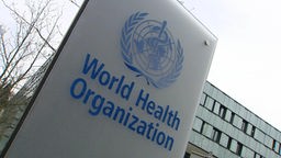 Logo und Schild der Weltgesundheitsorganisation WHO an einem Gebäude