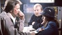 Schimanski (Götz George) und Christian Thanner (Eberhard Feik) sitzen mit dem Mädchen Katja (Anja Jaenicke) an einem Tisch.