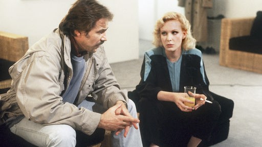 Schimanski (Götz George) und Miriam Schultheiß (Sunnyi Melles) sitzen auf einem Sofa.