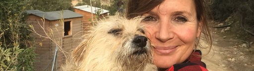 Moderatorin Simone Sombecki steht in griechischen Bergen und hält einen Hund im Arm