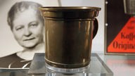 Der erste Melitta-Kaffeefilter und ein Foto seiner Erfinderin Melitta Bentz in einer Vitrine des Melitta-Archivs.