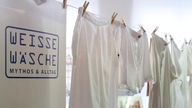 Weiße Wäsche hängt im Museum Wäschefabrik auf der Leine.