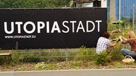 Großer Banner am Zaun mit der Aufschrift von Utopiastadt in Wuppertal.