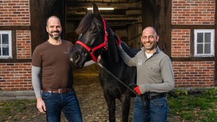 Das Bild zeigt Holger Thoms und Peter Richterich mit Pferd in der Mitte.