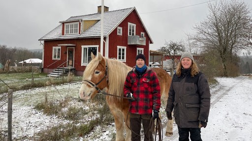 Viavian und Alex mit neuem Arbeitspferd vor ihrem Haus in Schweden.