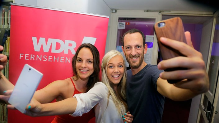 Die YouTuber Gianna Chanel, Julia Fljat und Jan Winter machen mit ihren Handys ein "Selfie-Foto"