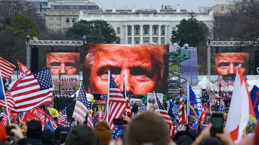 Eine riesige Menschenmenge vor dem Weißen Haus in Washington, davor drei riesige Bildschirme mit dem Gesicht von Donald Trump