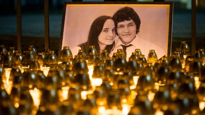 Ein Foto von Ján Kuciak und Martina Kusnirova, davor viele Kerzen 