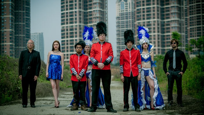 Eine Gruppe kostümierter Schauspieler vor Hochhäusern