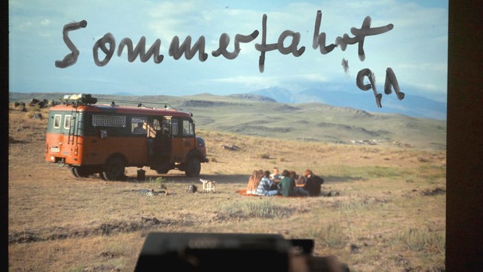 Dia-Foto zeigt eine Gruppe junger Leute neben einem Reisebus sitzend