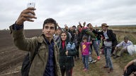 Flüchtling macht ein Selfie Foto von sich, Familie und Freunden