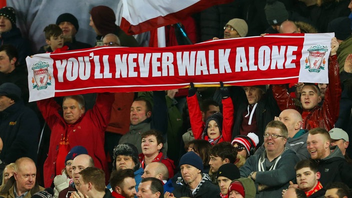 Liverpoolfans halten ein "You'll Never Walk Alone"-Banner hoch