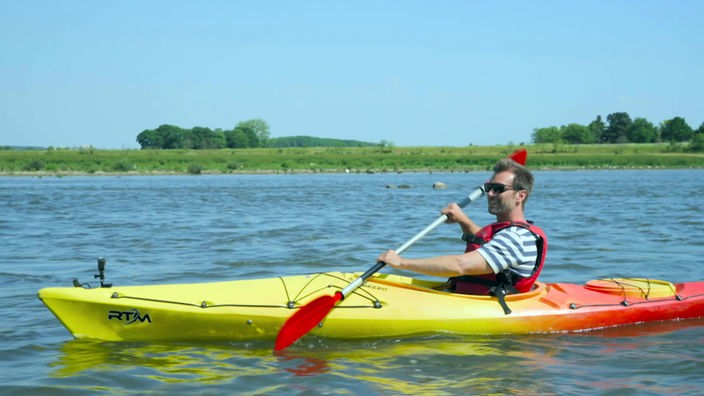Daniel Aßmann paddelt mit dem Kanu auf der Maas 
