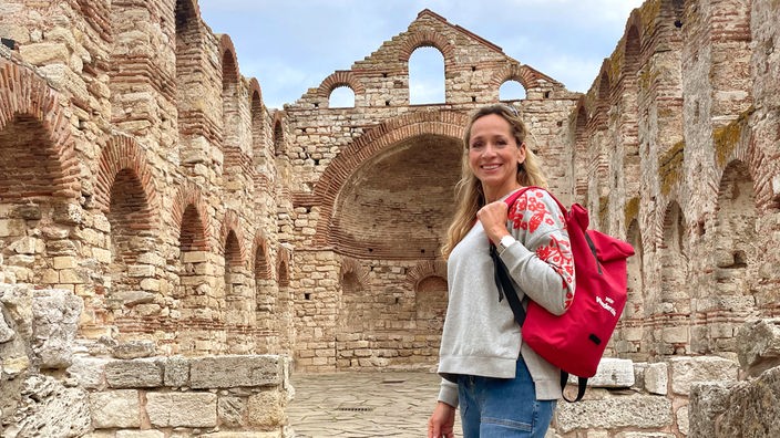 Tamina Kallert steht inmitten der Ruinen einer romanischen Kirche im bulgarischen Ort Nessebar