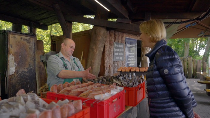 Judith Rakers schaut sich die Auslage  einer Fischräucherei an