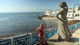 Die Statue einer Ausschau aufs Meer haltenden Frau im Hafen von El Cotillo