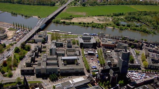 Blick von oben auf ein modernes Stadtviertel an einem kleinen Fluss