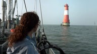 Anne Willmes schaut von Bord eines Schiffes auf den Leuchtturm Arngast