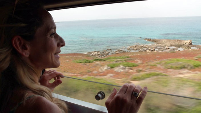 Tamina Kallert schaut aus einem Zugfenster auf die vorbeiziehende Landschaft