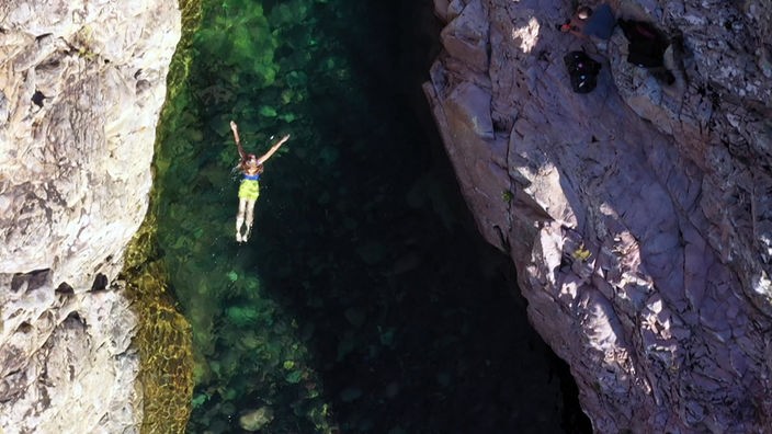 Tamina Kallert schwimmt in einem schmalen Flusstal zwischen hohen Felswänden