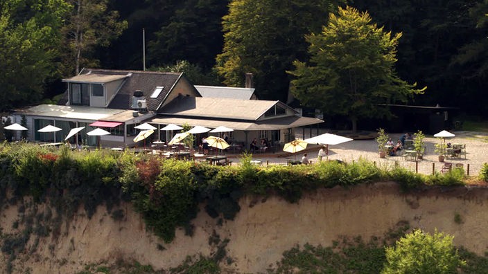 Gasthaus mit Außengastronomie am Rande einer Steilküste