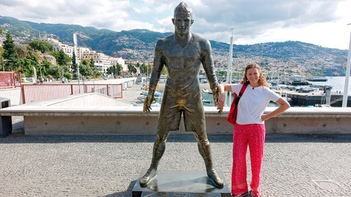 Anne Willmes steht neben der Bronzestatue des Weltfußballers Ronaldo