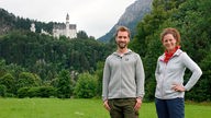Anne Willmes und Daniel Aßmann, im Hintergrund Schloss Neuschwanstein