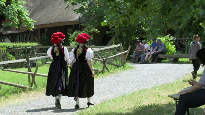 Zwei Frauen in Tracht und mit Bollenhüten im Freilichtmuseum Vogtsbauernhof