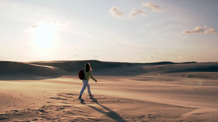 Tamina Kallert wandert durch eine wüstenähnliche Sandlandschaft