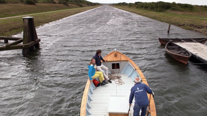 Tamina sitzt mit einem Begleiter und dem Bootsführer in einem Boot auf dem Frederik VII. Kanal