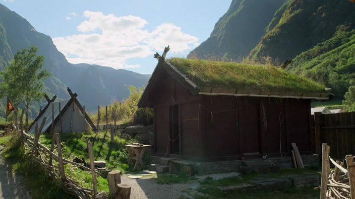 Kleine Holzhäuser in einem Bergtal