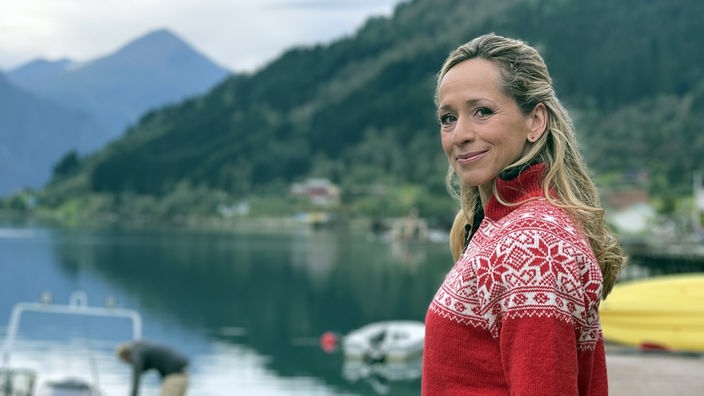 Tamina Kallert steht an einem See in Berglandschaft