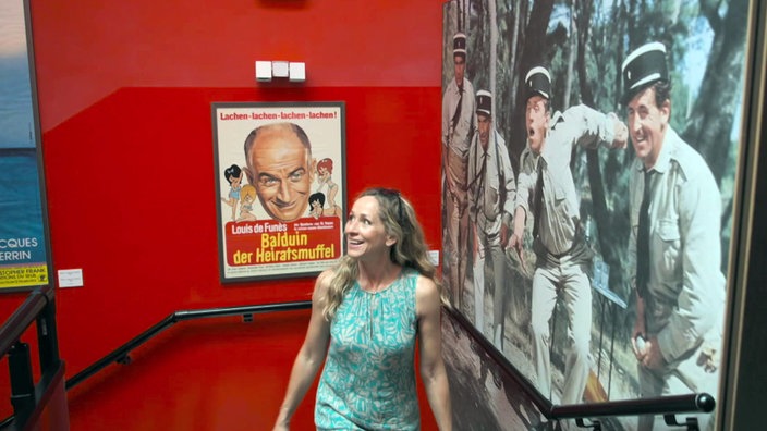 Tamina Kallert vor Filmplakaten im Musée de la Gendarmerie et du Cinéma in St. Tropez