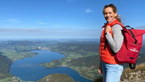 Tamina Kallert mit rotem Rucksack auf dem Schafberg mit Blick auf den Mondsee