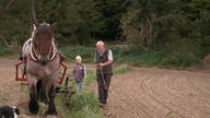 Kurt Ohrndorf und sein Enkel mit einem Pferdewagen bei der Kartoffelernte
