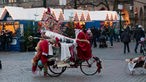 Nikolaus auf einem Fahrrad fährt über einen Weihnachtsmarkt