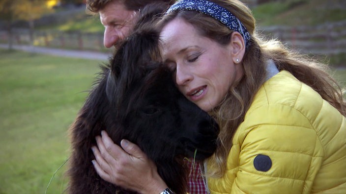 Tamina Kallert kuschelt mit einem Alpaka